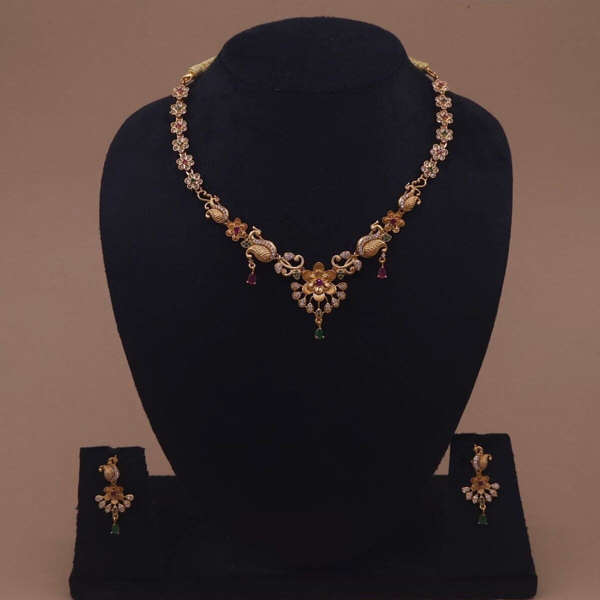 Khianaa peacock motif earrings and necklace set side angle with dangling green drops